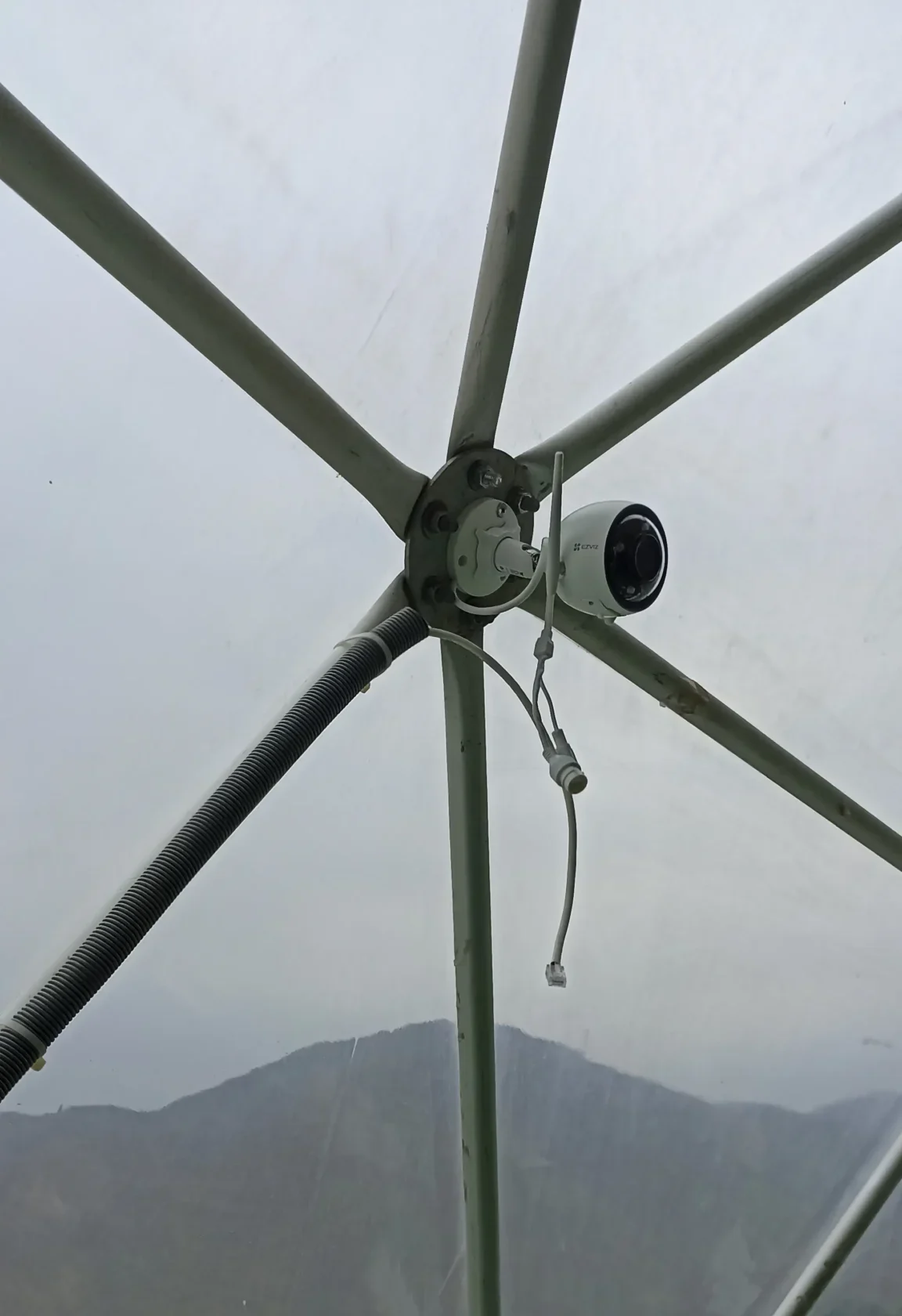 Cámara IP instalada en estructura geodésica con vista al valle de La Libertad — integración de videovigilancia en arquitectura no convencional de proyecto turístico