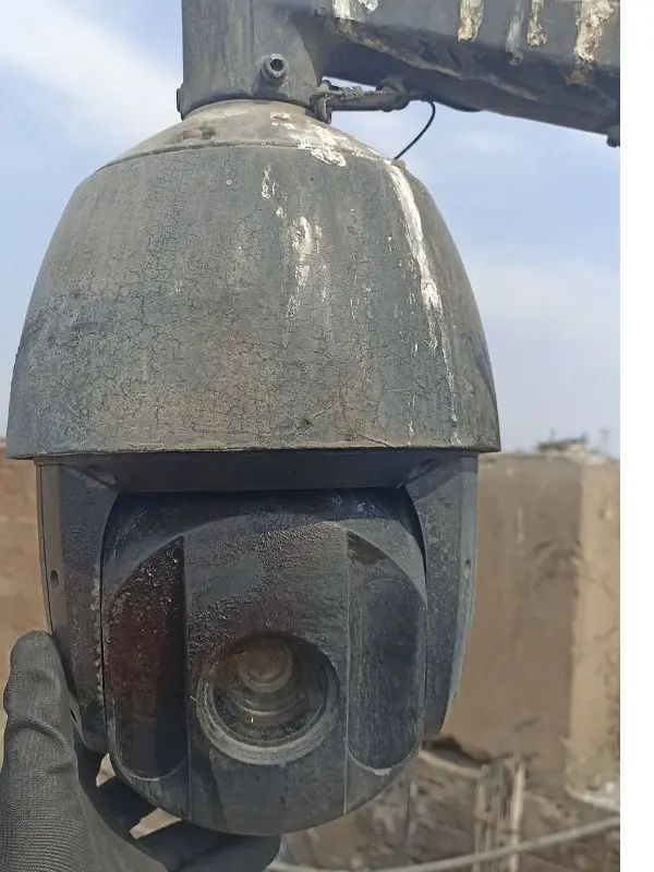 Cámara PTZ speed dome deteriorada después de 3 años sin mantenimiento en Lima: pintura agrietada, corrosión generalizada, sangre coagulada de paloma visible en el mecanismo de giro y domo opaco con suciedad acumulada