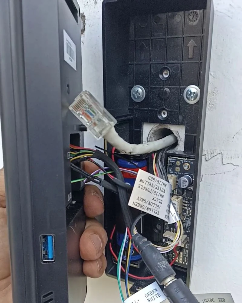 Interior del terminal biométrico mostrando el cableado RJ45 y conexiones durante la instalación