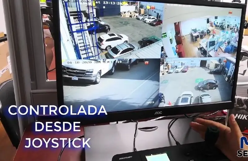 Monitor de videovigilancia mostrando cuatro vistas de cámaras en tiempo real controladas desde joystick PTZ en sala de monitoreo