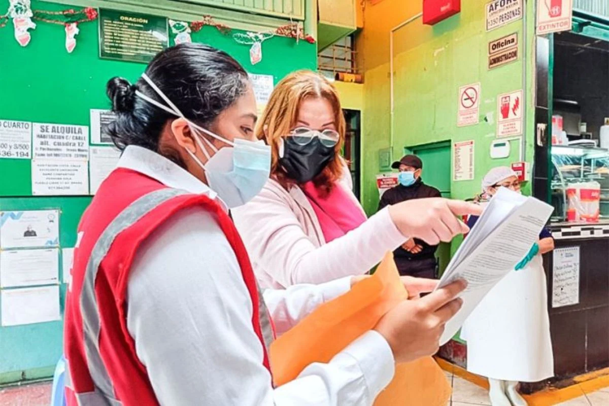 Inspectora de SUNAFIL revisando documentación de control de asistencia durante una fiscalización en empresa peruana