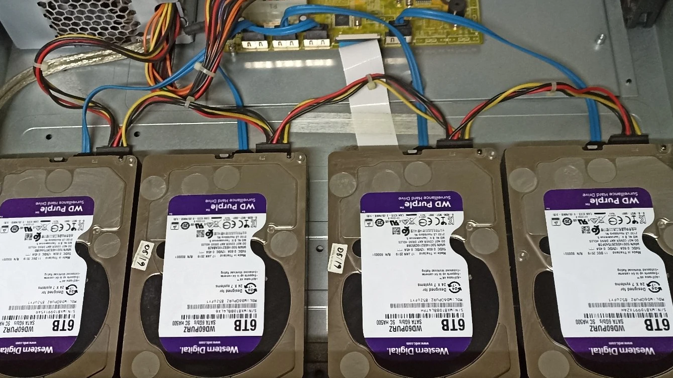 Interior de DVR Hikvision abierto con discos duros y cables SATA visibles