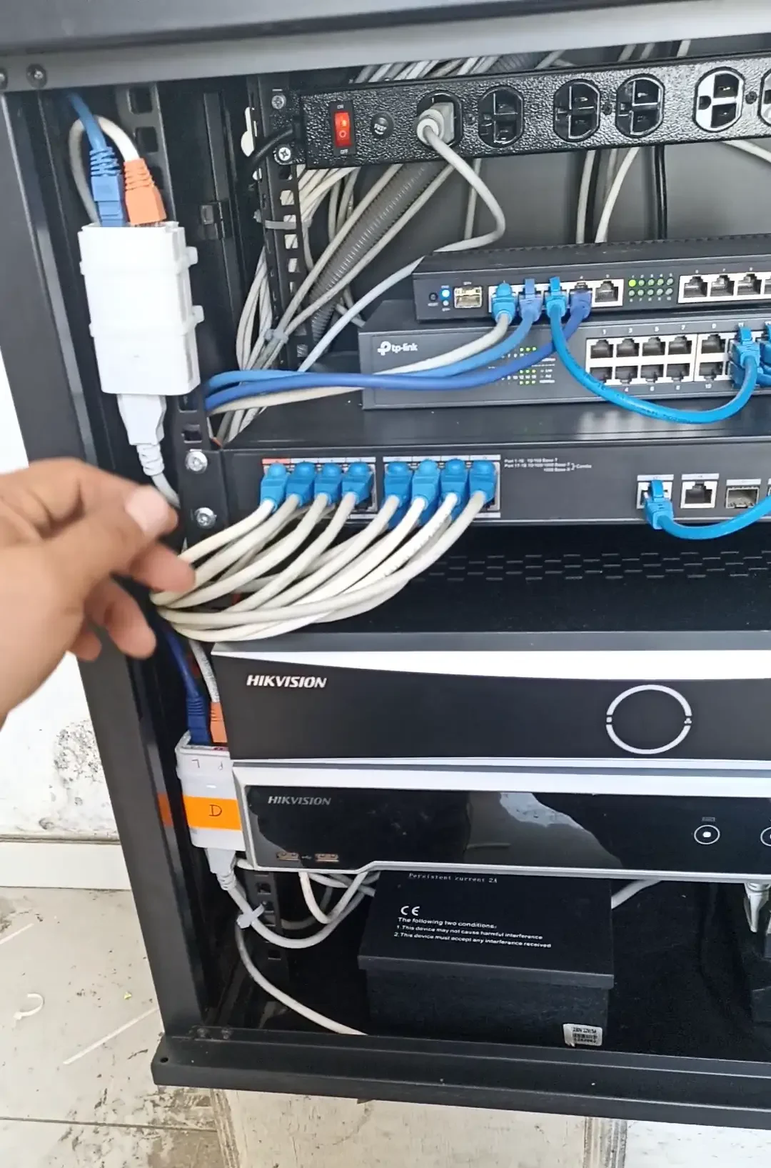 Rack abierto mostrando switches PoE TP-Link, NVR Hikvision y cableado estructurado del sistema de videovigilancia con cámaras IP en La Libertad, Perú