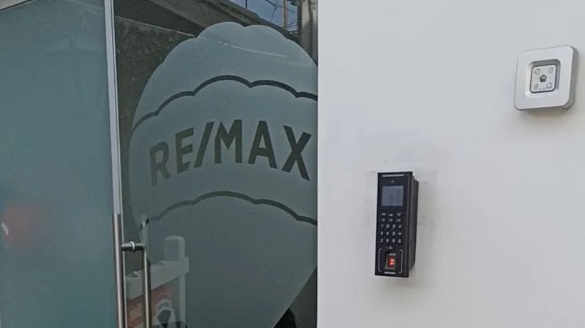 Reloj biométrico de control de asistencia instalado en pared de entrada de empresa peruana